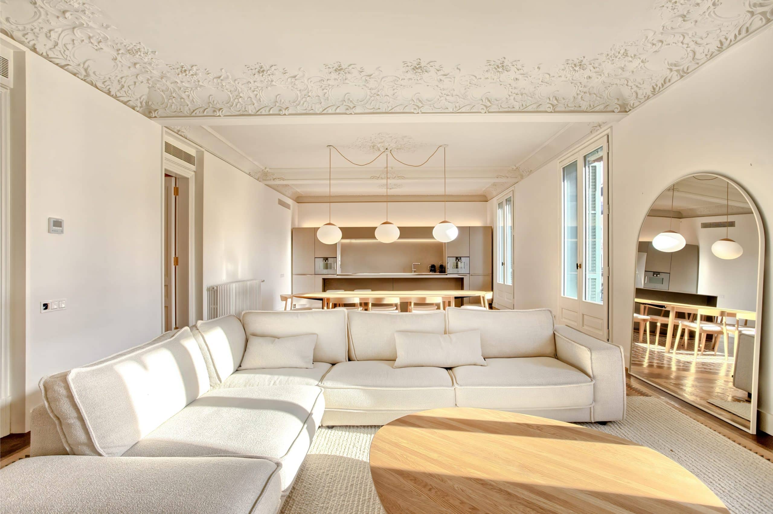 Salón con sofá en L y comedor al fondo