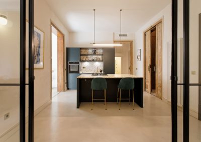 Cocina moderna con isla central y sillas verdes tapizadas