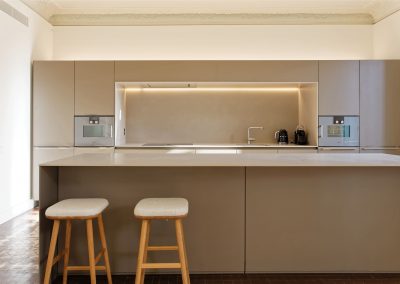 Cocina minimalista con barra y taburetes de madera