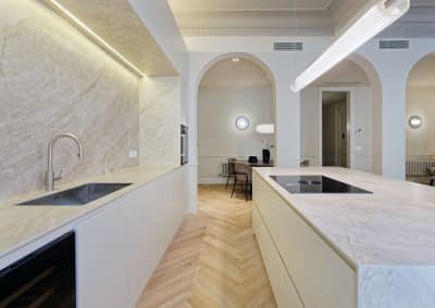 Cocina minimalista con isla central y paredes en mármol