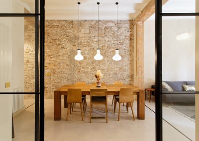 Comedor moderno con pared de ladrillo visto y lámparas colgantes