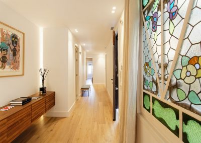 Pasillo interior con luz natural y vidriera decorativa