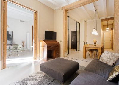 Sala de estar moderna con pared en tono cálido y vigas de madera