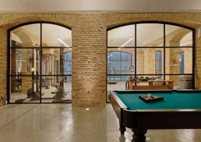 Sala multiusos con mesa de billar y máquinas de ejercicio