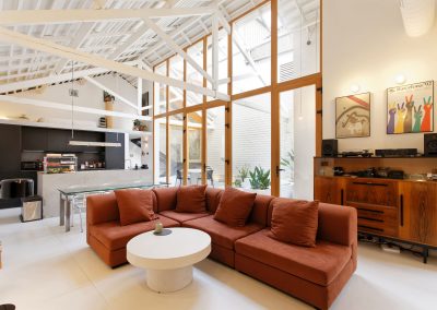 Salón amplio con sofá esquinero en tonos rojizos