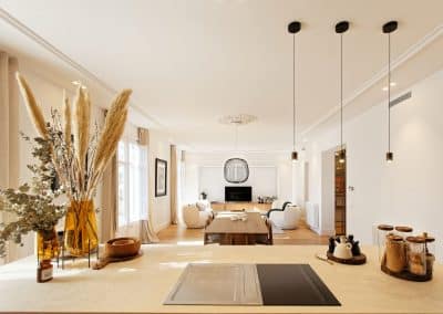 Salón luminoso visto desde la cocina con decoración en tonos cálidos