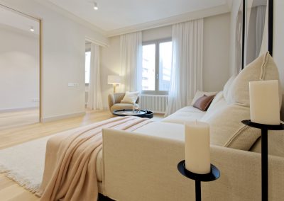 Zona de estar con sofá claro y luz natural