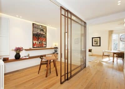 Despacho luminoso con mampara de cristal y suelo de madera